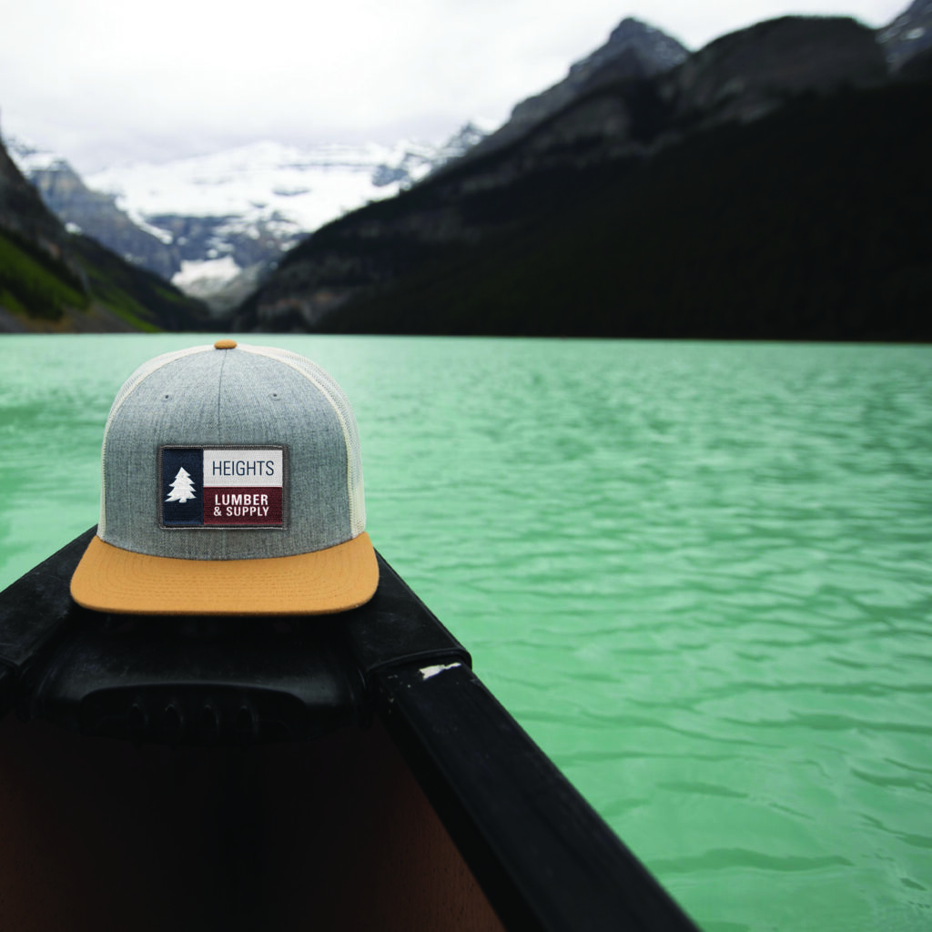 Heights Lumber branded hat on a canoe